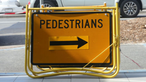 Close-up of yellow arrow symbol on road