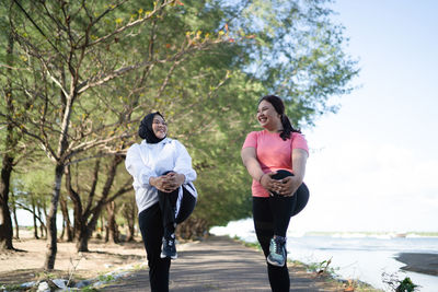 Rear view of couple standing against trees