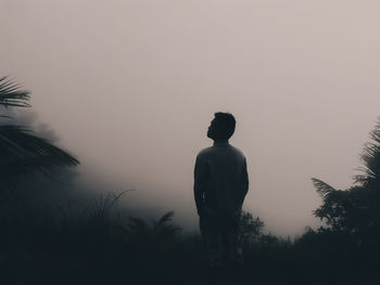 Rear view of silhouette man standing against clear sky