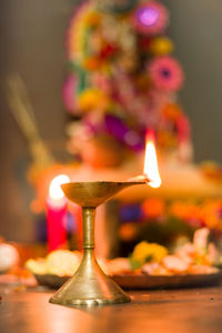 Close-up of lit candle on table