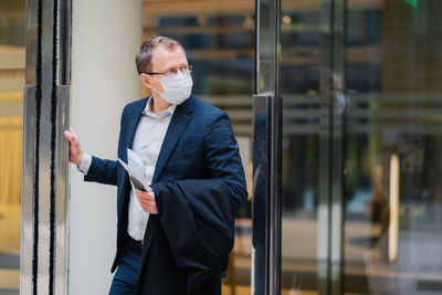 Businessman looking away while standing at entrance