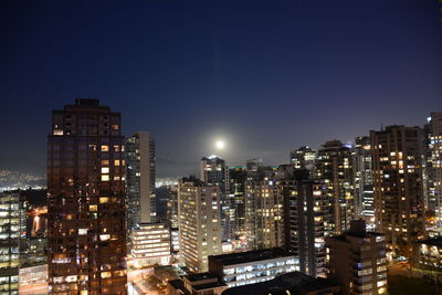 Illuminated buildings against sky at night