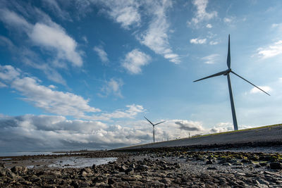 Wind turbines on land against sky