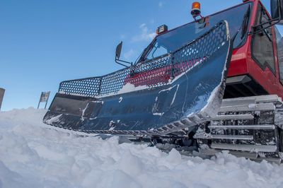 Snow covered boat on field against sky