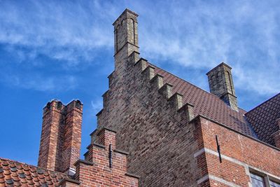 Low angle view of old building against cloudy sky