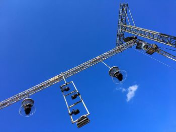 Low angle view of stage lights on construction frame against blue sky