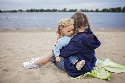 Boy sitting on sand at beach