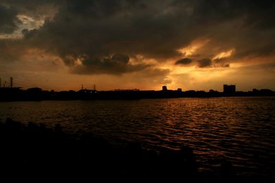Scenic view of sea against cloudy sky during sunset