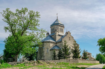 Old church of the early 20th century in village. old tree near the cult building