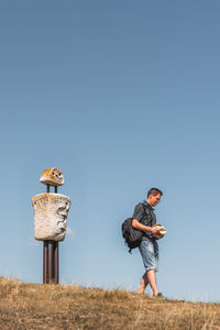 Full length of man standing on field against clear sky