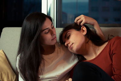 Young women relaxing on sofa at home