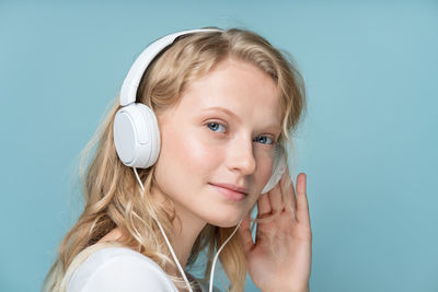 Portrait of teenage girl looking away against blue background