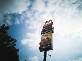 Low angle view of road sign against sky