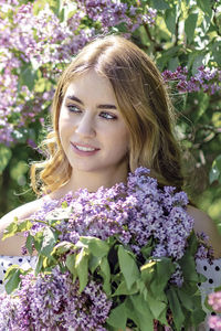 Portrait of a smiling young girl in blooming lilac trees. summer time,vacation.