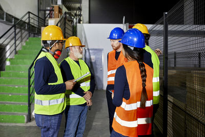 Workers standing in factory warehouse talking