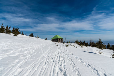 Scenic view of snow covered land against sky