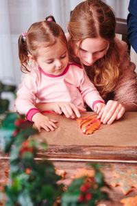 Mother and daughter preparing gingerbread cookies at home