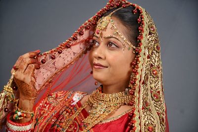 Beautiful young bride standing against wall