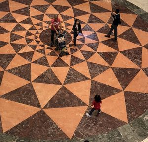 High angle view of people walking on tiled floor