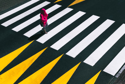 Low section of woman walking on zebra crossing