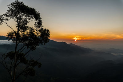 Scenic view of silhouette mountains against sky at sunset