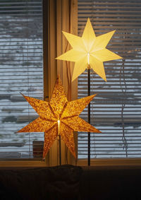 Close-up of yellow umbrella on window