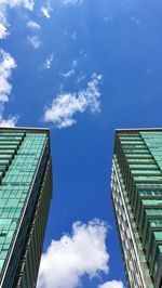 Low angle view of modern buildings against blue sky