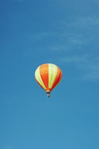 Low angle view of hot air balloon against clear blue sky