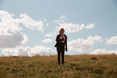 Full length of woman standing on field against sky