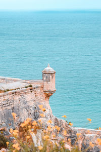 Scenic view of sea against sky and small tower