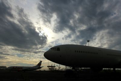 Airplane on runway against sky