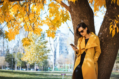Beautiful woman using smart phone at public park