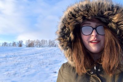 Portrait of smiling young woman standing in snow