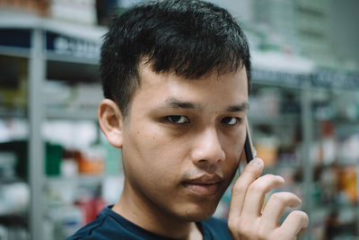 Close-up portrait of young man talking on mobile phone