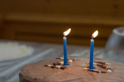 Close-up of illuminated candles on birthday cake