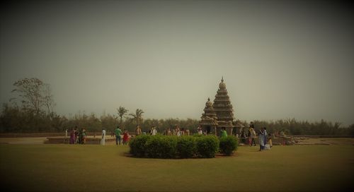 People at temple against sky