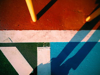 High angle view of shadow against colored footpath
