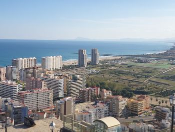 High angle view of buildings and sea against sky