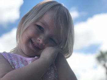 Portrait of cute girl smiling against sky