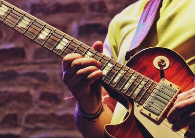 Midsection of musician playing guitar