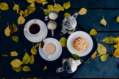 High angle view of autumn leaves by breakfast in tray on table