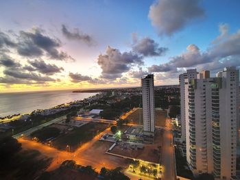 Panoramic view of illuminated buildings against sky during sunset