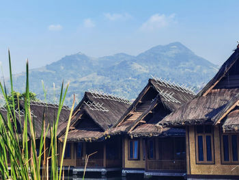 Houses by lake against sky