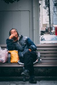 Man sitting on snow in city