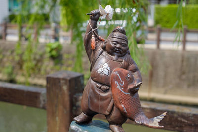 Close-up of statue against wooden wall