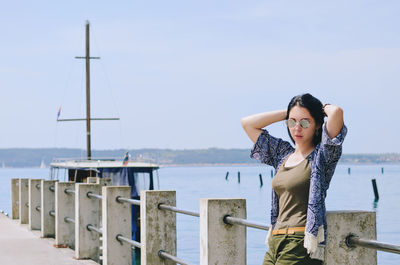 Young woman standing against sea