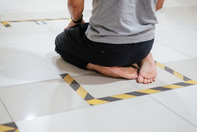 Low section of man sitting on tiled floor