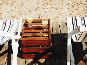 High angle view of deck chairs with drinks on table at beach