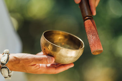 Woman performing sound healing therapy in nature with tibetan singing bowl