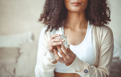 Midsection of teenager girl holding beauty serum